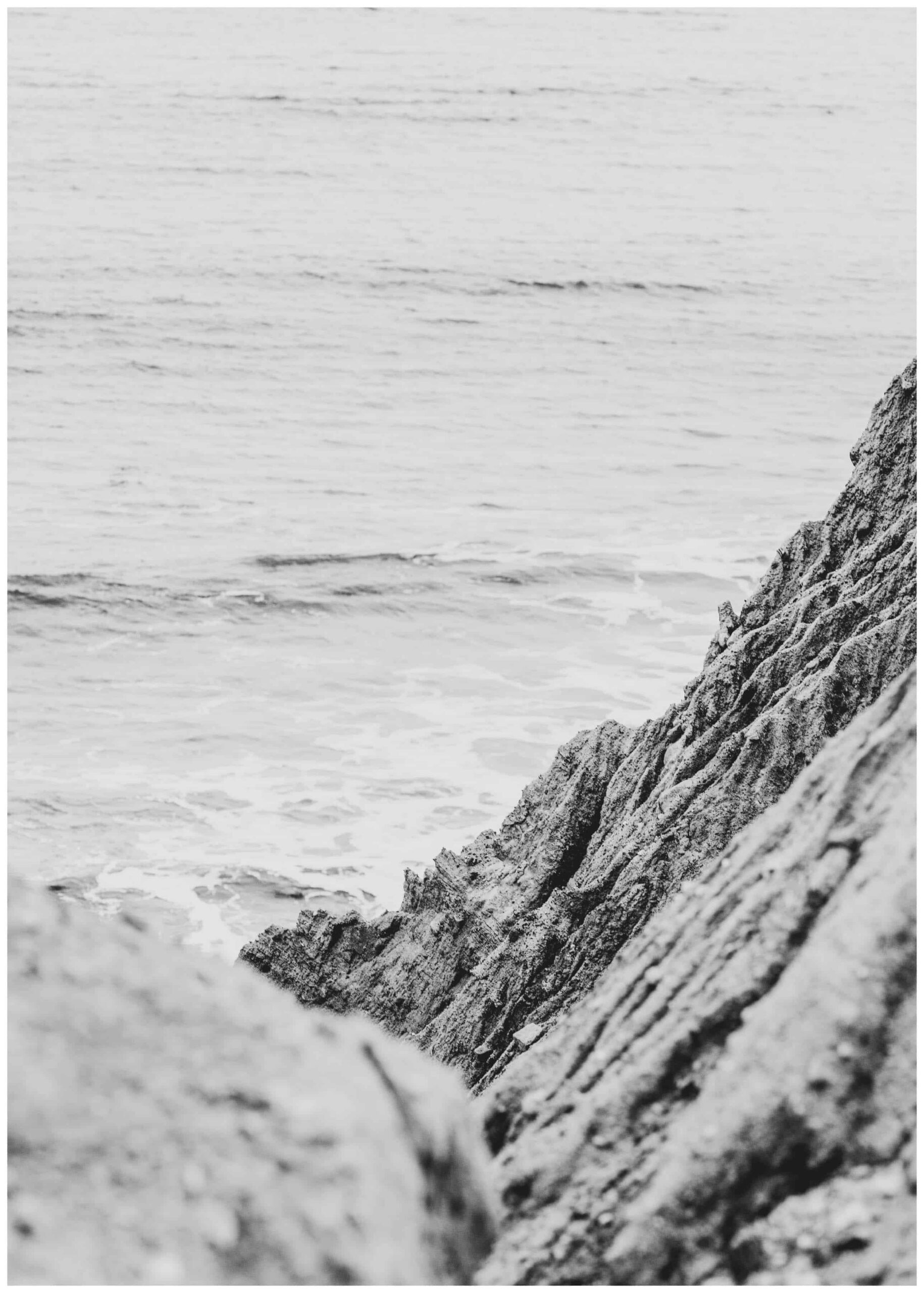 rock formation beside body of water poster